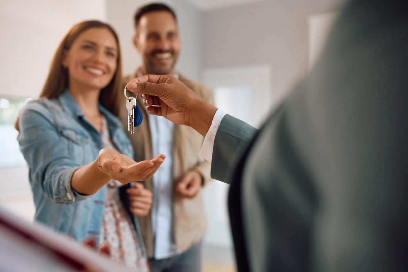 family grabbing keys to new house ©Drazen Zigic
