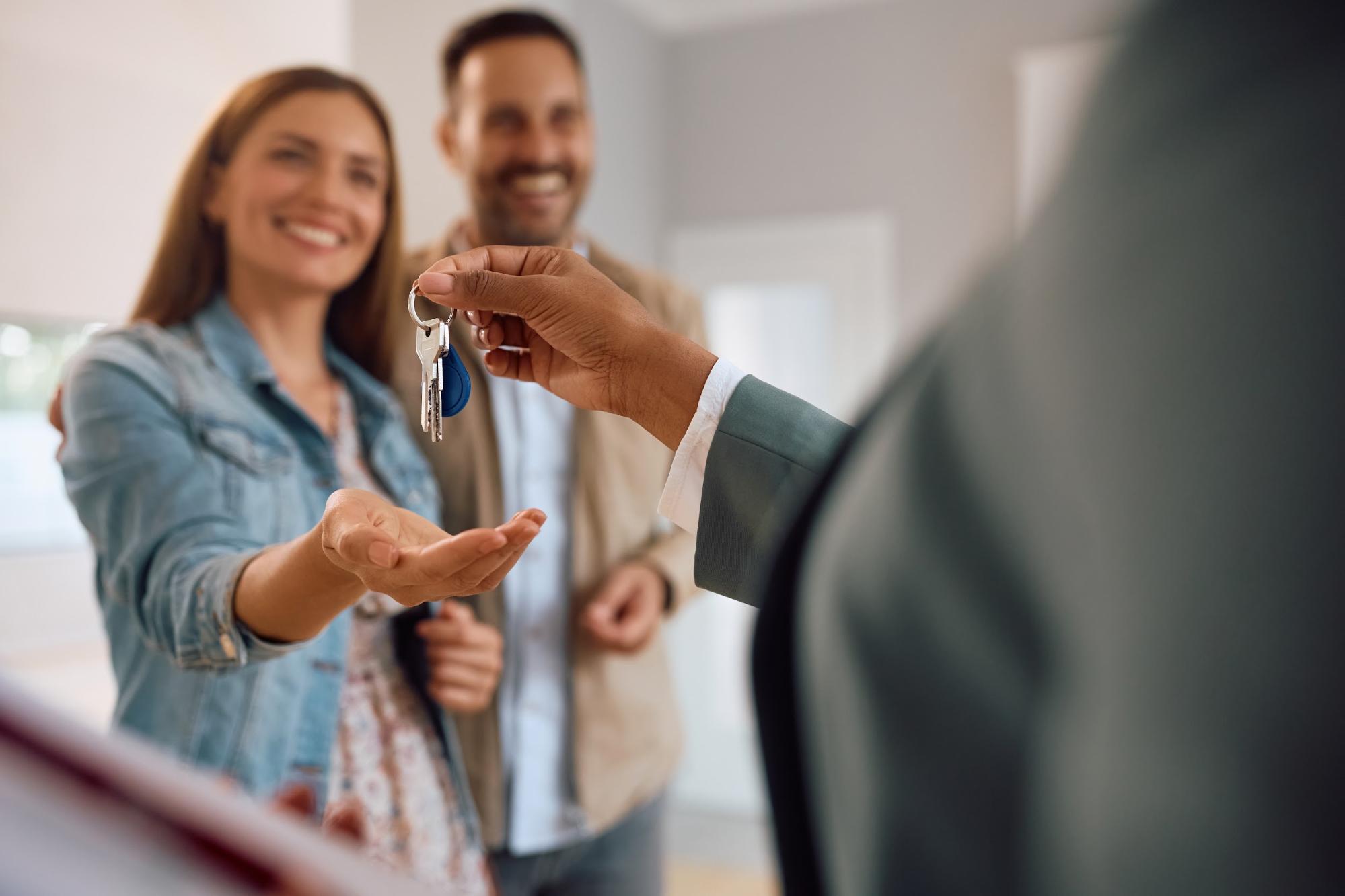 family grabbing keys to new house ©Drazen Zigic