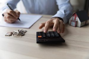Close-up of person using calculator for budgeting tips for first time homebuyers ©fizkes