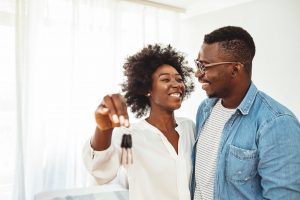 Happy first time homebuyers holding keys in their new construction home ©Dragana Gordic