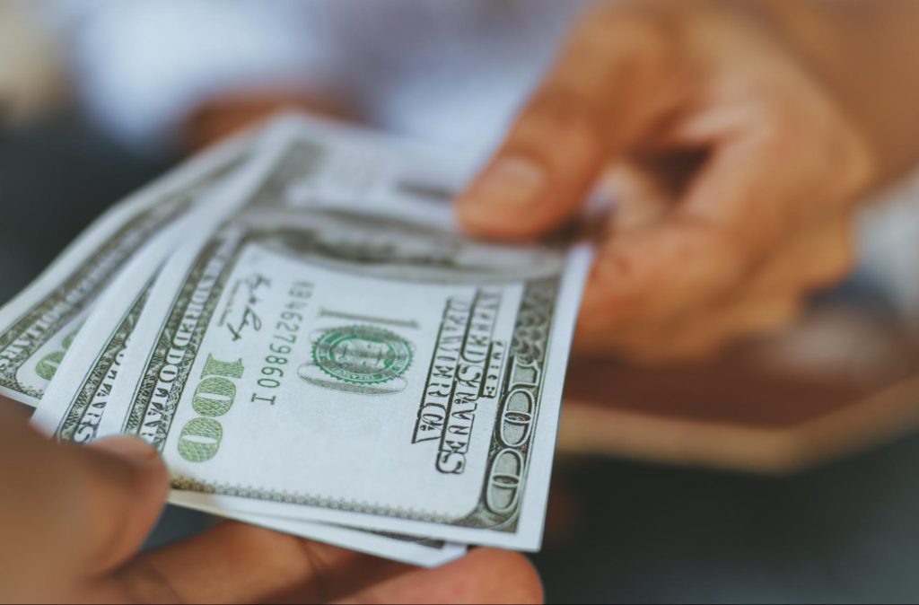 Person paying with money, representing someone buying a home in Metro Atlanta ©hugo_34