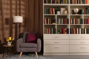 Cozy home library with bookshelves, armchair, and reading lamp ©New Africa