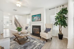 Decorated living room in Fairview Lake with fireplace, coffee table, artwork, and greenery.