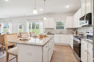odern, decorated kitchen with granite countertops, white cabinets, and stainless steel stove and microwave.