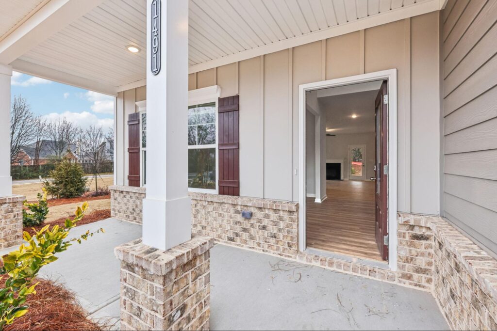 Front porch with brick accents at Stephen's Landing, a new community in Loganville. The front door is open and inviting.