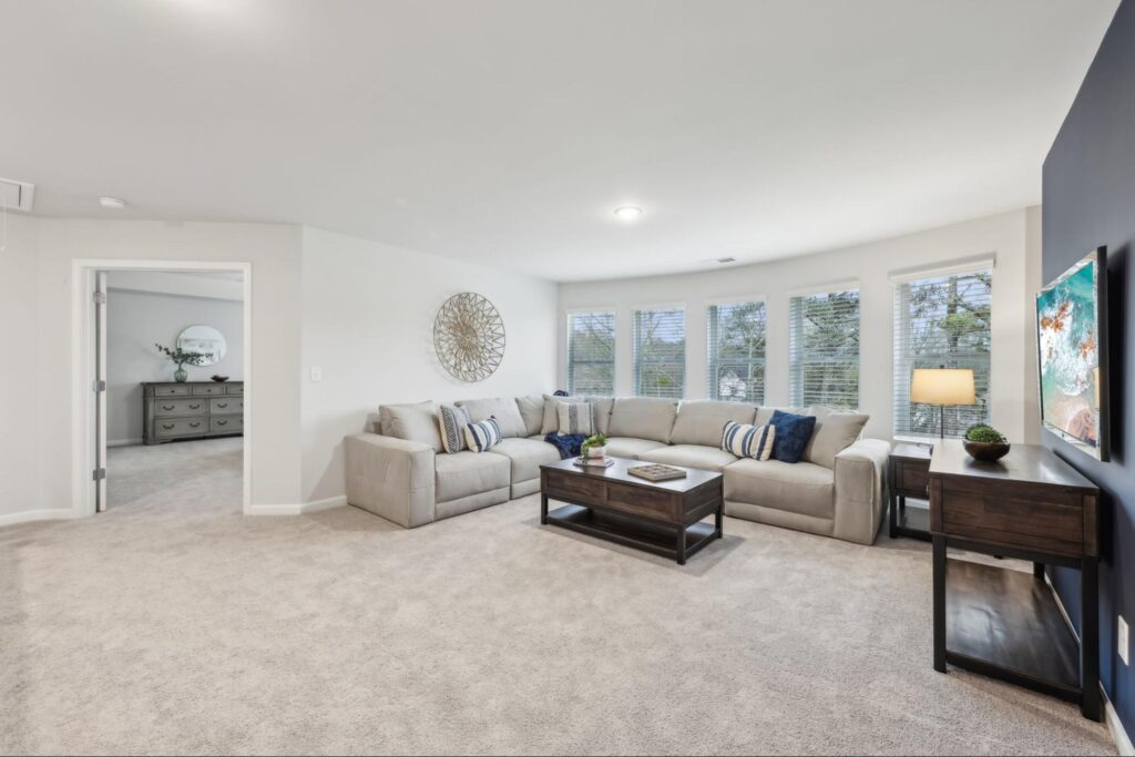 View of the back of a new home with an extended covered back patio and fenced-in backyard.