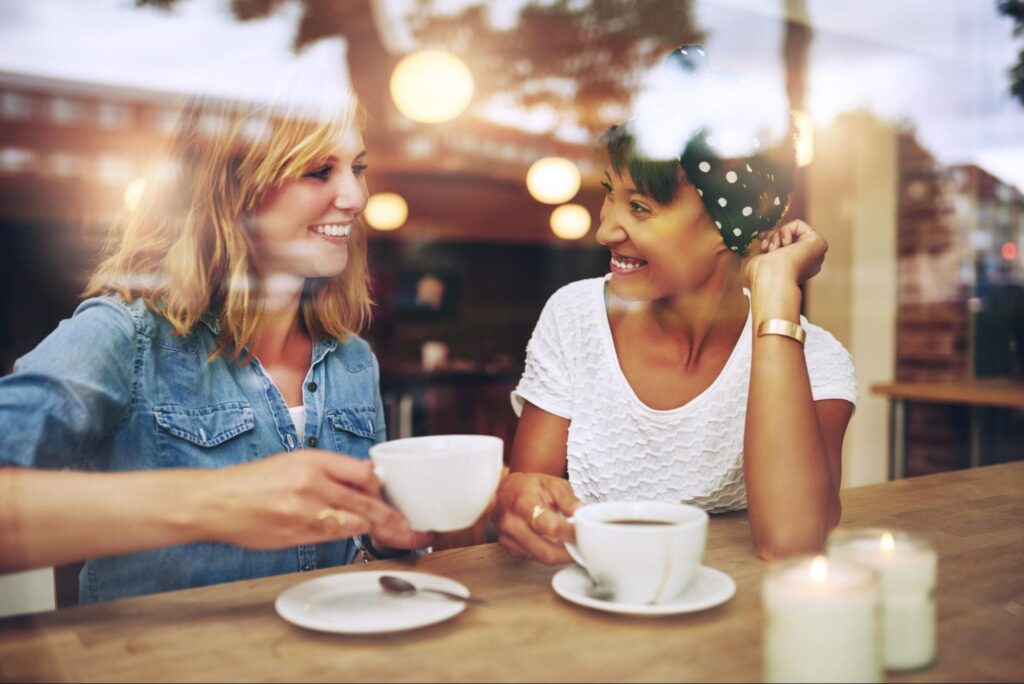 Two women enjoying coffee together at a café, representative of downtown Woodstock, GA.
©Ground Picture
