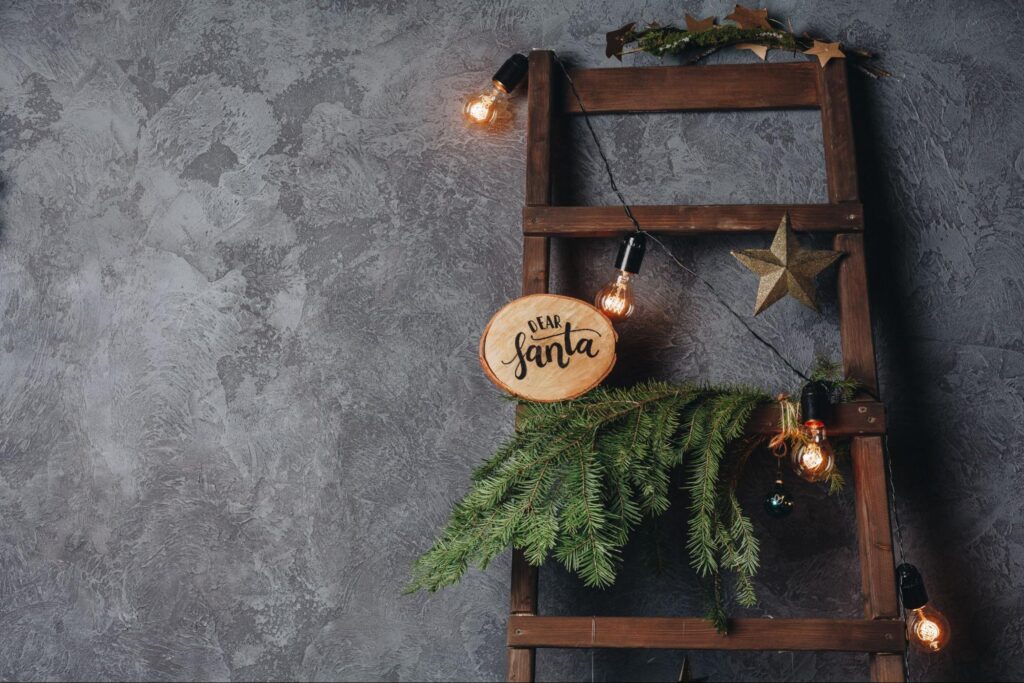  Wooden ladder decorated with pine branches, Christmas lights, and star ornaments. ©EG_photo