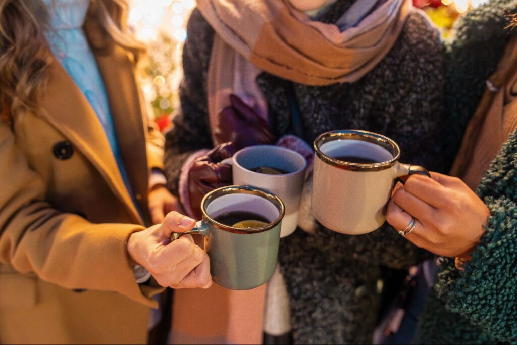Hands holding warm drinks at a Christmas market in Heath ©Lomb