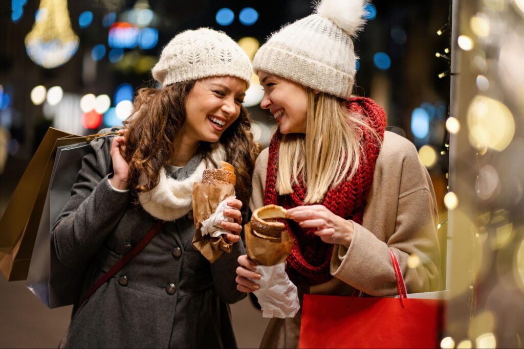 Two women in winter clothes laughing while Christmas shopping ©NDAB Creativity