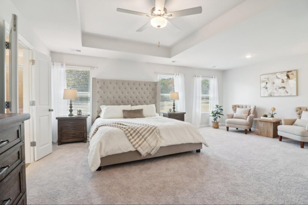Large primary bedroom with tray ceiling in a new construction home at Neely Farm.