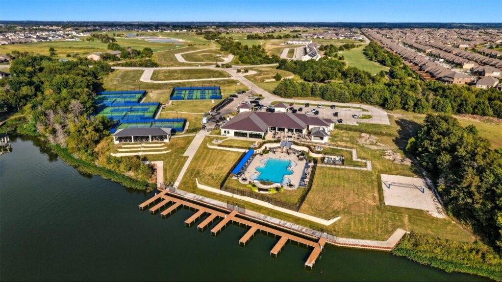 Aerial view of Heath Golf & Yacht Club showing resort-style pool, boat slips, and courts near Lake Ray Hubbard