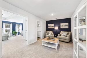 Cozy primary suite sitting area with a navy accent wall at The Hills at Cedar Creek.