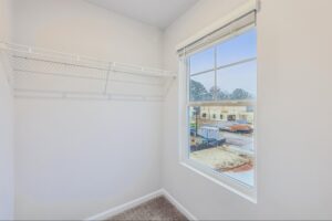 Large walk-in closet with built-in shelving and natural light. 
