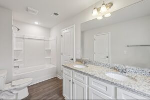 Shared upstairs bathroom with double sinks and tub-shower combo. 