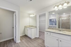 Spa-inspired primary bathroom with double vanity and granite countertops. 