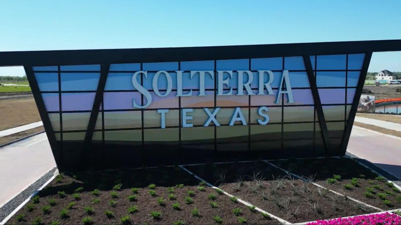Large monument entrance sign for Solterra Texas community under a clear blue sky.