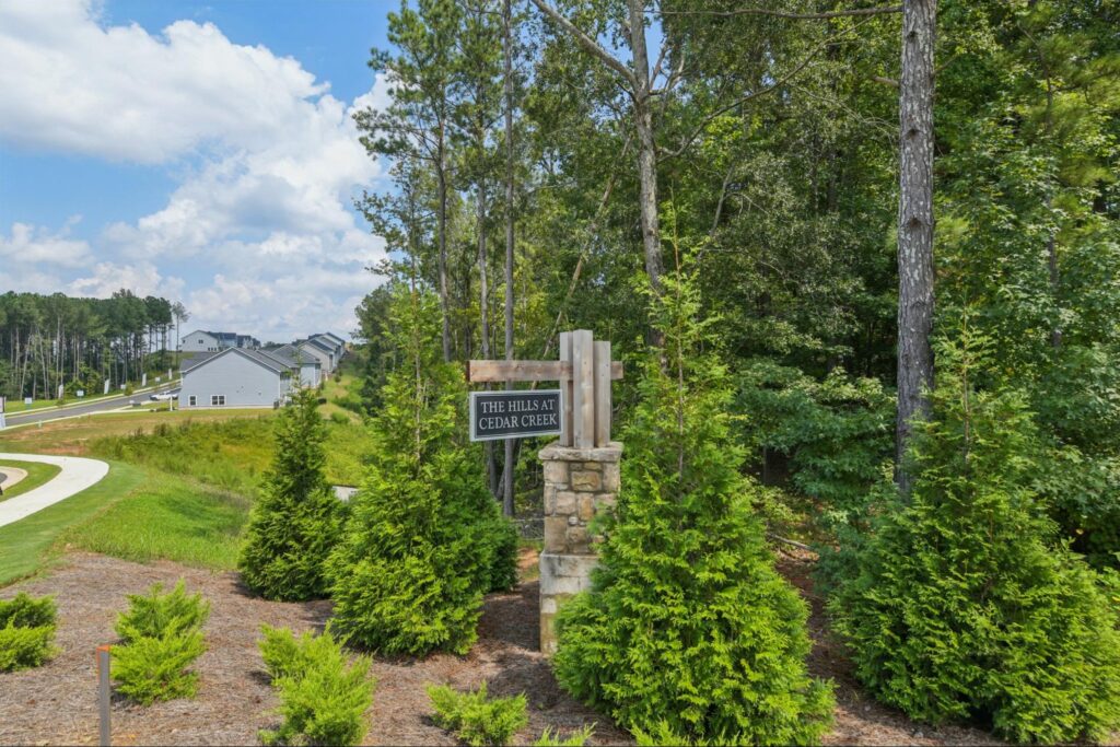 Stone entrance sign for The Hills at Cedar Creek new home community in Winder, Georgia.