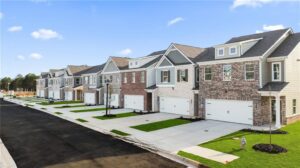 Row of modern new townhomes with garages and private driveways at Fairview Lake Townhomes in Conyers, Georgia.