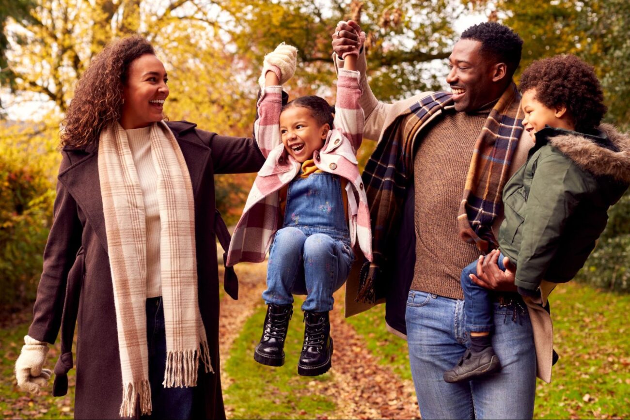 Happy family of four walking outdoors together on a sunny autumn day. ©Monkey Business Images